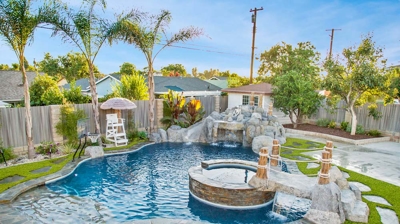 Freeform pool with spa in backyard Photo