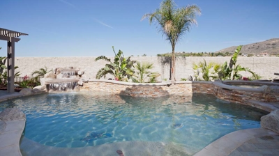 Custom freeform pool with waterfall and landscaping detail Photo