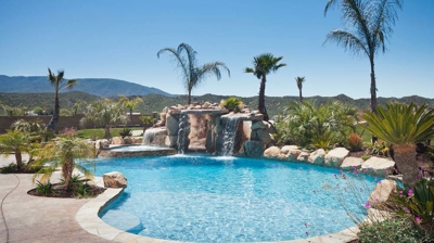 Custom patio with freeform pool and waterfall Photo