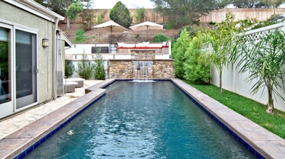 Long backyard pool with cascading waterfall Photo