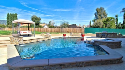 Patio with seating, pool, and round spa Photo