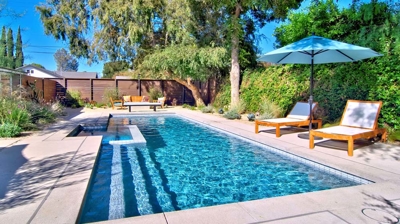 Pool and chaise lounges with green landscaping Photo
