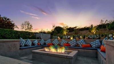 Sunken outdoor seating area with fire pit at night Photo