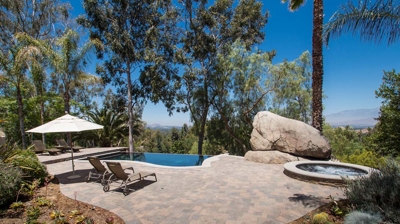 Small pool with infinity edge design and patio Photo