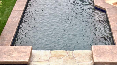 Backyard spa and pool with waterfall edge Photo