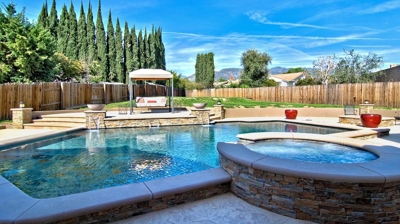 Spa attached to pool with spa attached with waterfall and fire features. Photo