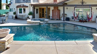 Pool with attached spa with fire feature bowls. Photo