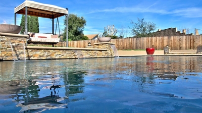 Covered bench swing behind waterfall features with fire on top. Photo