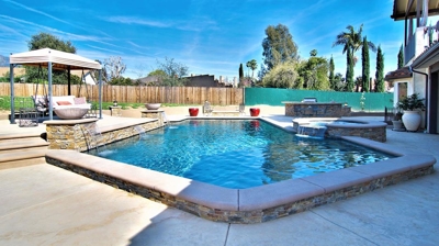 Pool with spa attached with waterfall and fire features. Photo