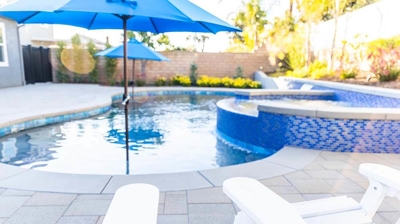 White Adirondack chairs encircling a poolside paradise. Photo