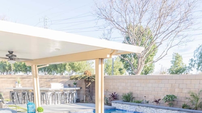 L-shaped pool in the backyard with a spa enhanced by delightful water features. Photo
