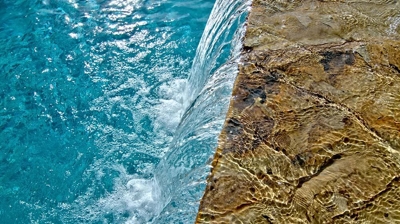 Waterfall integrated into a backyard pool setting. Photo