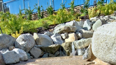 A pool adorned with a backyard waterfall. Photo