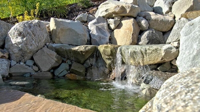 Backyard oasis featuring a pool and waterfall combination. Photo