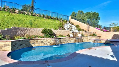 A backyard paradise enhanced by cascading waterfalls and a sparkling swimming pool. Photo