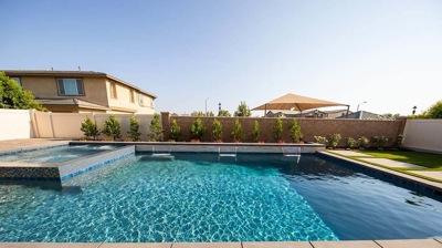Contemporary outdoor retreat highlighting a pool-spa fusion, bordered by grass pavers. Photo