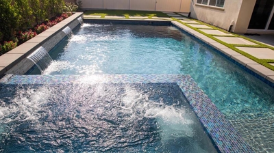 Backyard escape with a spa-pool ensemble framed by verdant grass pavers. Photo