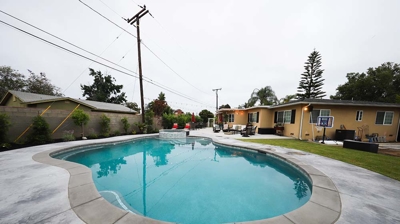 Subterranean backyard swimming pool accompanied by an elevated spa. Photo