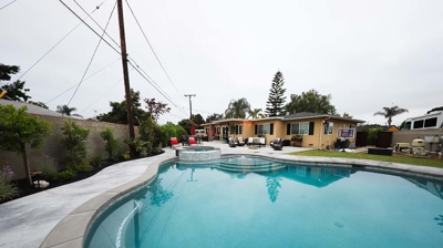 In-ground backyard swimming pool combined with an above-ground spa. Photo