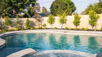 Backyard oasis featuring a pool elevated by the presence of a spa for enhanced aesthetics. Photo