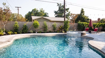 Recessed backyard pool featuring an above-ground spa for added allure. Photo