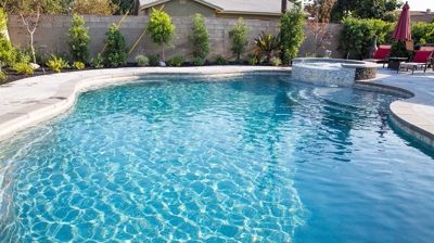 Backyard pool enhanced by an elevated spa, elevating the overall aesthetic. Photo