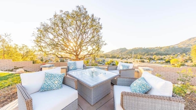 An exquisite outdoor haven featuring a pool, verdant surroundings, a fire pit, and cozy seating. Photo