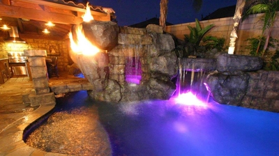 A twilight haven where the tropical pool is adorned with luminous hues and fiery embellishments. Photo