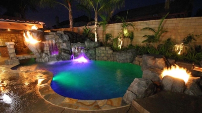 A midnight marvel, the tropical pool ensconced in a mesmerizing interplay of light and fire. Photo