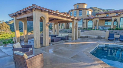 Gorgeous outdoor patio with pool and lawn chairs. Photo