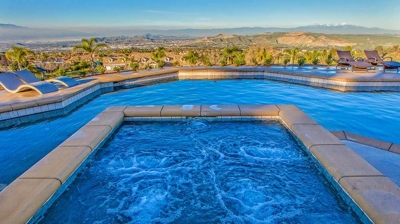Beautiful view of pool and jacuzzi with stone floor and scenery. Photo