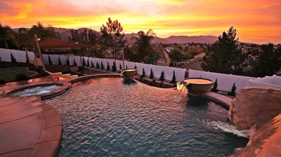 Shot of pool and jacuzzi with orange sunset view. Photo