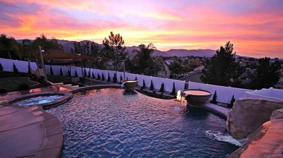 Shot of pool and jacuzzi with orange sunset view. Photo