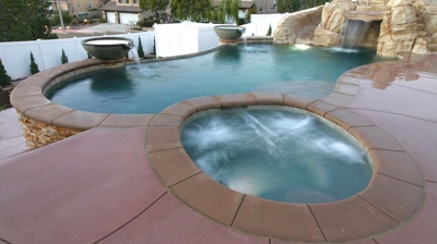 View of pool and jacuzzi with stone floors. Photo