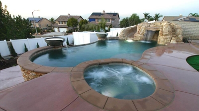 View of pool and jacuzzi with stone floors. Photo