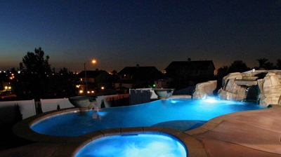 Lit up jacuzzi and pool in night time. Photo