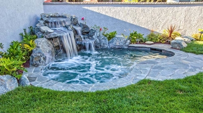 Inviting backyard escape featuring a mesmerizing waterfall and earthy rock accents. Photo