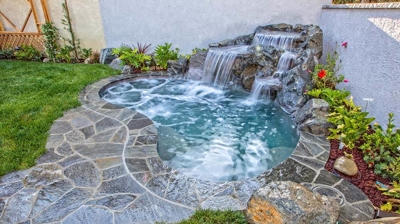 Tranquil spa retreat nestled amidst lush greenery and a soothing waterfall. Photo