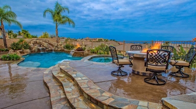 Tranquil tropical retreat boasting a pool, spa, and mesmerizing fire accents, with a fire pit. Photo