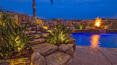 Tropical oasis retreat with a pool, spa, and mesmerizing fire features. Photo