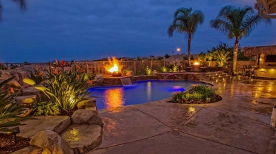 Island-inspired backyard haven boasting a pool, spa, and outdoor fire elements. Photo