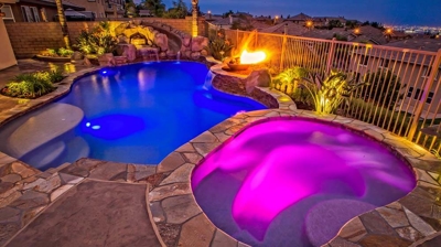 Resort-style backyard retreat with a pool, spa, fire elements, and hints of island charm. Photo