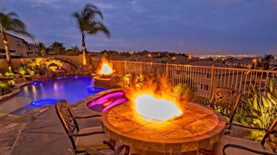 Blissful backyard paradise reminiscent of a tropical island, featuring pool, spa, and fiery accents. Photo