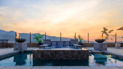 Luxurious outdoor haven: pool, elevated spa, waterfall, and radiant fires. Photo