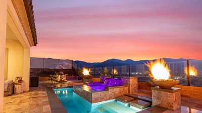 Harmonious backyard sanctuary: pool, spa above, waterfall, fiery ambiance. Photo