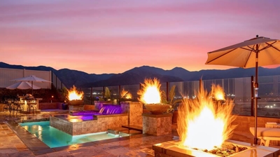Radiant poolside haven: elevated spa, cascading waterfall, fiery atmosphere. Photo
