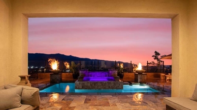Spectacular backyard pool and elevated spa with a cascading waterfall encircled by fiery accents. Photo
