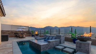 Pool and spa combo, waterfall, embraced by mesmerizing flames. Photo