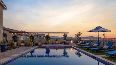 Inviting pool and spa area with loungers, offering idyllic sunset views. Photo