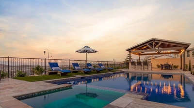 Blissful backyard oasis boasting pool, spa, lounge chairs, and sunset vistas. Photo